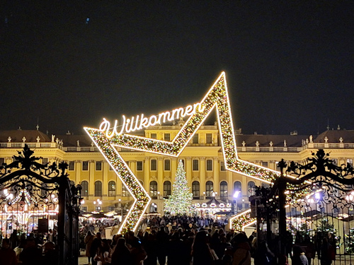 Entrance to a Christmas market with a palace backdrop